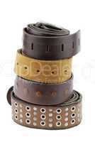 Stack pile of leather belts on white