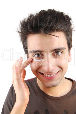 Smiling man applying eye cream
