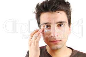 Handsome man applying eye cream