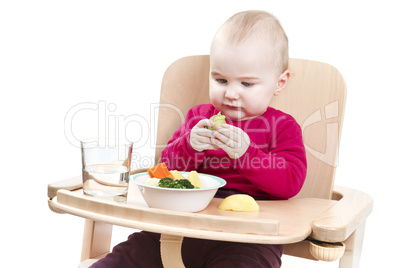 young child eating in high chair