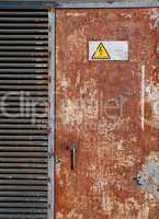 High voltage sign on a rusty door