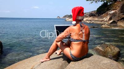 Woman using laptop on the beach