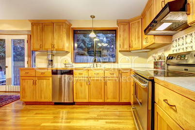 Golden wood kitchen with hardwood floor.