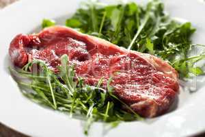 raw loin steak on rocket salad