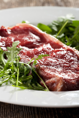 raw loin steak on rocket salad