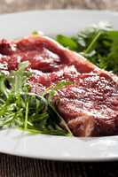 raw loin steak on rocket salad