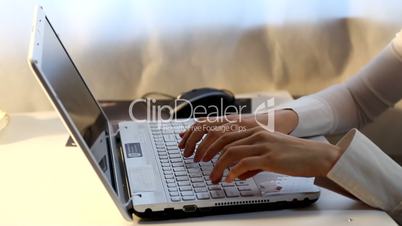 Hands typing on a laptop keyboard