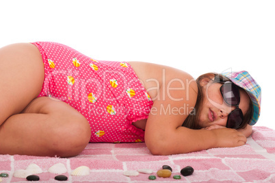 Girl in swimsuit sleeping at the beach
