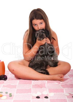 Girl in swimsuit at the beach kissing her dog