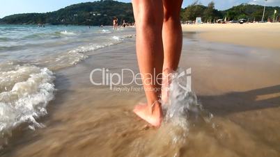 Beautiful women's feet in the surf