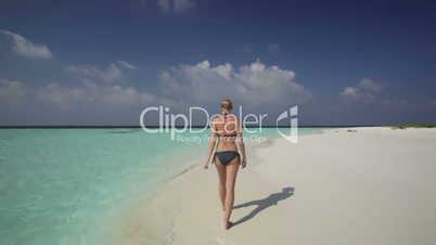beautiful woman in bikini walking on beach