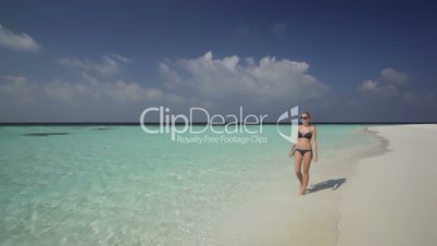 beautiful woman in bikini walking on beach