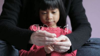 Mother Trimming Little Girls Fingernails