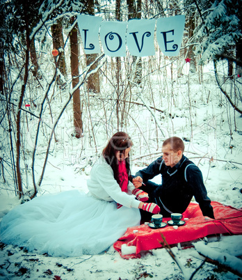 Couple in love in winter forest drinking tea. Couple in love in winter forest drinking tea.