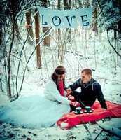 Couple in love in winter forest drinking tea.