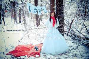 Girl with red scarf in white snow forest with love.