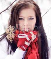 Beautiful woman with red gloves in winter forest.