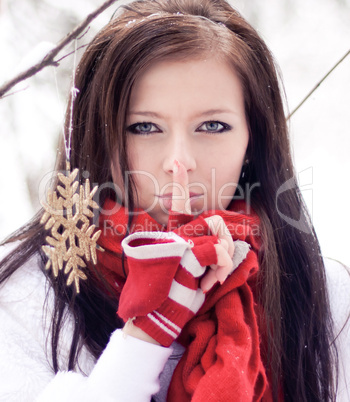 Beautiful woman with red gloves in winter forest.