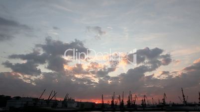 Silhouette of several cranes in a harbor, shot during sunset. Odessa, Ukraine (Time Lapse)