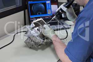 Videoendoskopie. Ein Mitarbeiter überprüft ein Teil des Getriebsgehäuses mit einem Videoendoskop