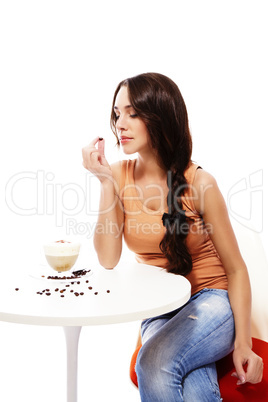 frau schaut auf die kaffee bohne in ihrer hand mit cappuccino auf dem tisch