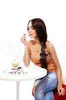 frau schaut auf die kaffee bohne in ihrer hand mit cappuccino auf dem tisch