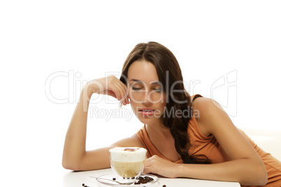 schöne frau schaut auf eine tasse cappuccino kaffee auf dem tisch