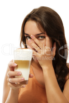 junge frau mit einem glas latte macchiato versteckt ihr gesicht hinter ihrer hand