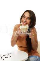 fröhliche junge frau mit einem glas cappuccino hat milchschaum auf ihrer nase
