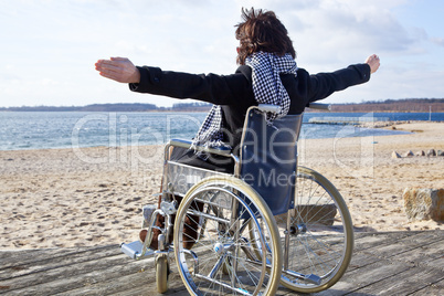 Frau im Rollstuhl am Strand