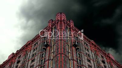 Timelapse storm clouds behind old derelict victorian warehouse