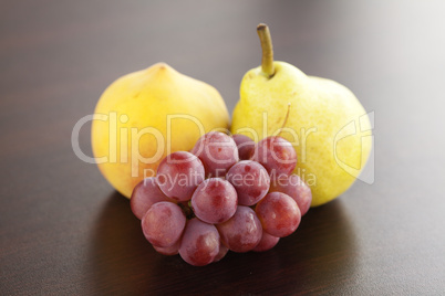 peach, pear and grapes lying on a wooden table
