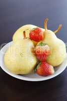 strawberries and  pears on a plate on a wooden table