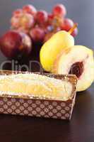 peach, pear, plum, coconut cake and grapes on a wooden table