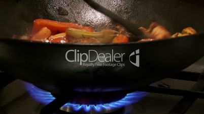 Chinese food in wok, flame, closeup