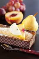 peach, pear, plum, coconut cake,spoon and grapes on a wooden tab