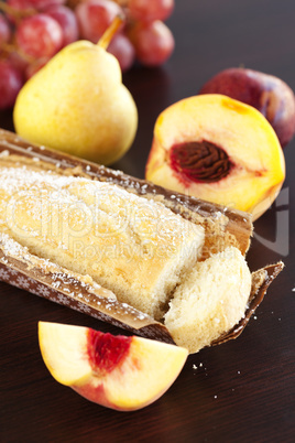 peach, pear, plum, coconut cake and grapes on a wooden table