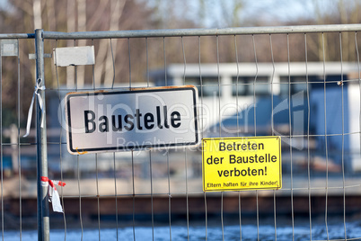 Baustellenschild und Betreten verboten Schild an einem Drahtzaun montiert