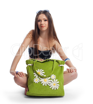 Yong woman posing with green beach bag isolated