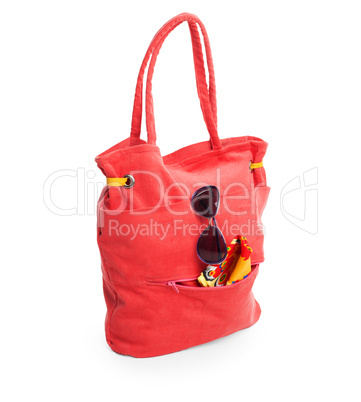 red beach bag with glasses and towel