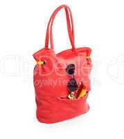 red beach bag with glasses and towel