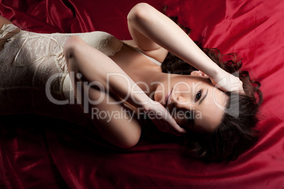 Young naked girl lay on red - close breast hands