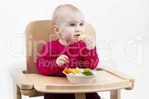 young child eating in high chair