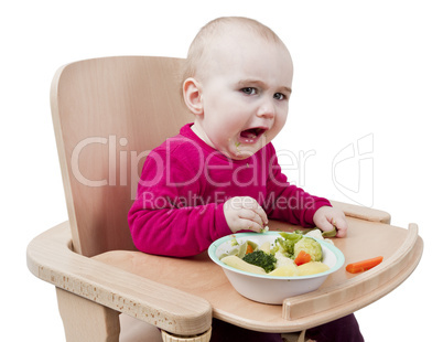 young child eating in high chair