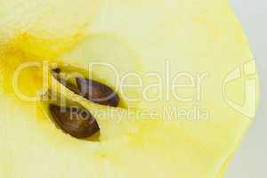 Yellow macro bisected apple with two brown seeds
