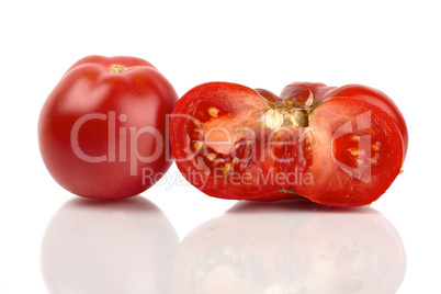 Zwei grosse Bio Tomaten, eine ganze und eine halbe gespiegelt vor weißem Hintergrund
