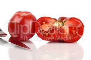 Zwei grosse Bio Tomaten, eine ganze und eine halbe gespiegelt vor weißem Hintergrund
