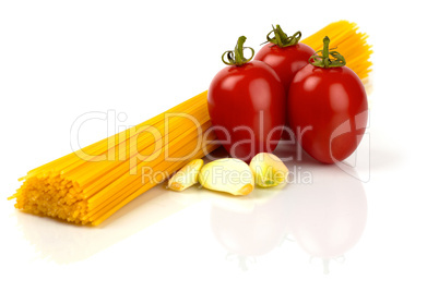 Spaghetti Nudeln mit Tomaten und Knoblauchzehen vor weißem Hintergrund