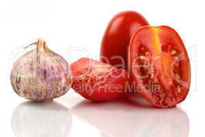 Frische Roma Tomaten mit einer Knoblauchzwiebel vor weißem Hintergrund