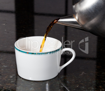 Tea poured from stainless steel teapot